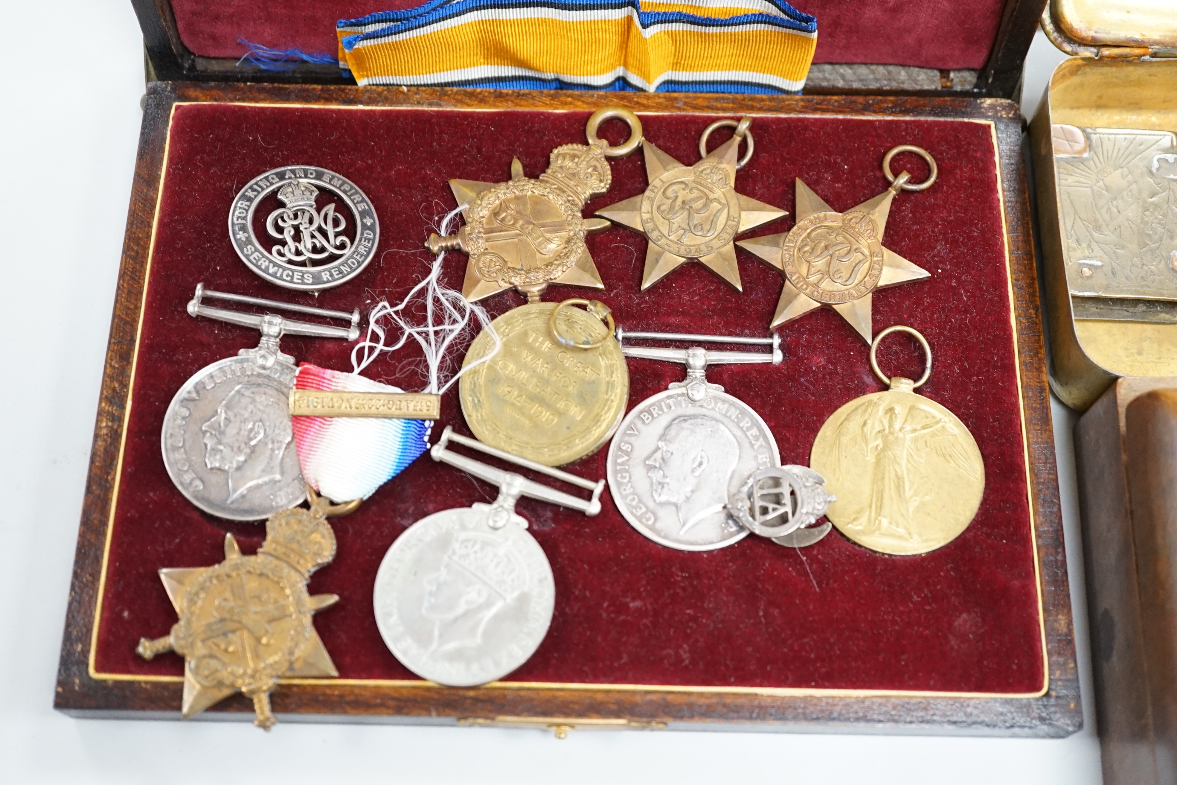 A quantity of war medals, Leicestershire brass paperweight, a carved box Somme Trench art match case and a gilt brass Christmas tin